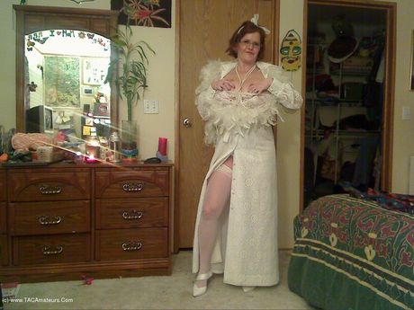 高齢のカナダ人女性、ミシャ・ミルフが素晴らしいおっぱいを披露し、白いストッキングでポーズをとる