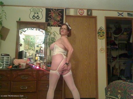 高齢のカナダ人女性、ミシャ・ミルフが素晴らしいおっぱいを披露し、白いストッキングでポーズをとる