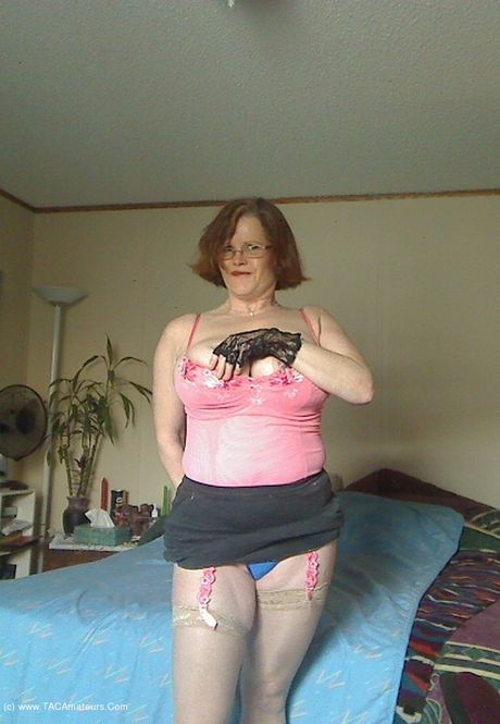 成熟的加拿大女士Misha Milf脫下內衣，穿著珊瑚色緊身胸衣擺姿勢