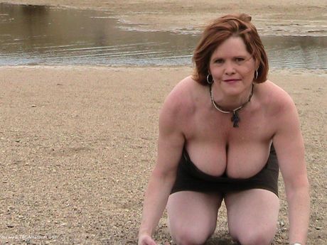 成熟したミシャ・ミルフは彼女の大きなおっぱいを強調し、ビーチで彼女の猫をおもちゃで遊ぶ