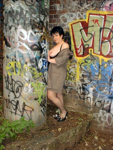 成熟的英國黑髮美女 Double Dee 展示她的大胸部並在大自然中擺姿勢