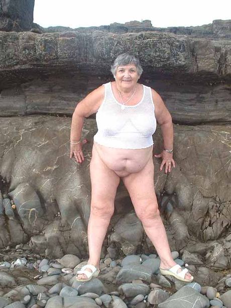 Voksen britisk dame Libby Ellis stripper til sine briller i en have