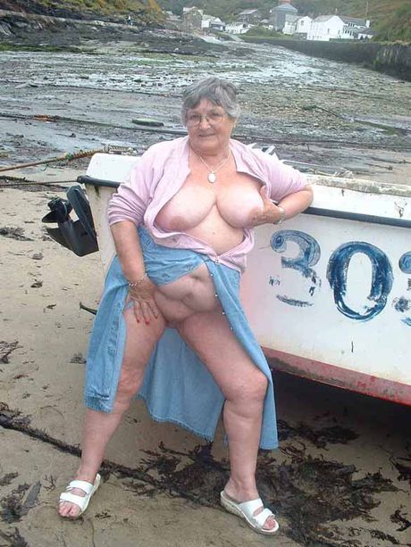 Voksen britisk dame Libby Ellis stripper til sine briller i en have