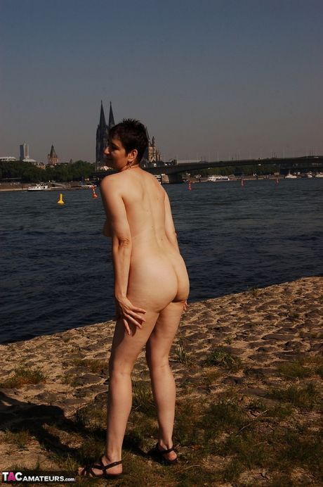 Fantastisk tysk cougar hot milf fremhæver sine fantastiske bryster og præsenterer sig naturligt på flodbredden