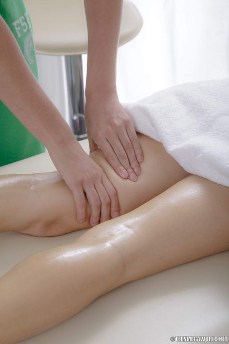 Dark haired teen Dinara gets a massage before sex on a bed