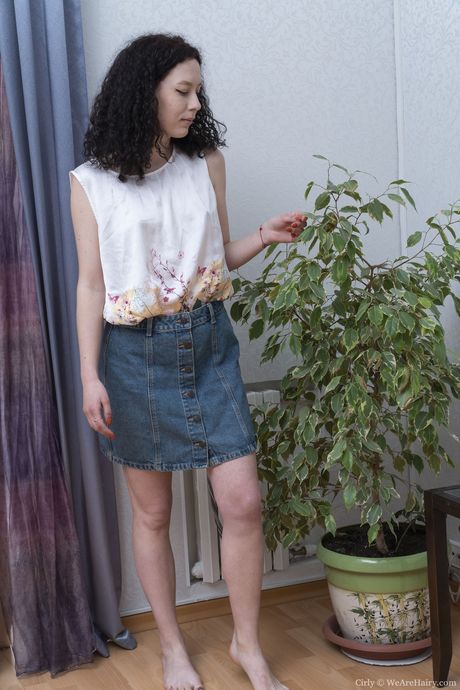 深色頭髮的少女赤身裸體後用捲曲的手指張開她的陰部