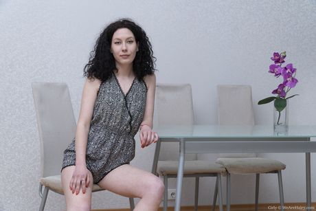 Mørkhåret teenager Krøllet finger spreder sin lyserøde fisse på en stol