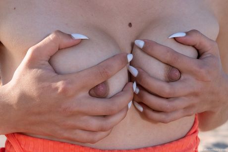 Tynd lettisk coverpige Polly Cute går nøgen på et tæppe på en sandstrand