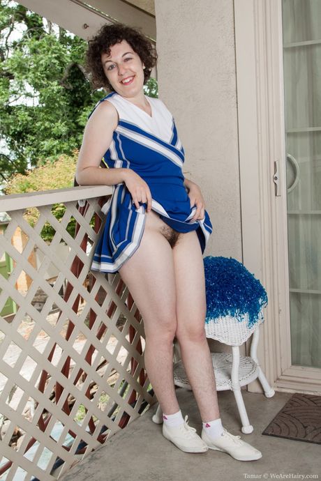 豊満な胸のチアリーダー、タマルが靴下まで脱いで毛深いオマンコを披露